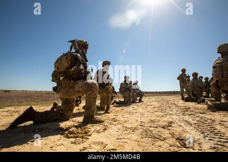 Soldaten, die Bravo Co., 1. Bataillon, 28. Infanterie-Regiment, 3. Infanterie-Division zugeteilt wurden, knieten sich hin, bevor sie am 25. März 2022 eine Feuerübung in Fort Stewart, Georgia, durchführten. Die Durchführung von leeren Feuerwehranlagen ermöglichte es den Soldaten, sich mit dem Gelände vertraut zu machen, und gab ihnen die Möglichkeit, sich vor der Brandübung unter Druck ordnungsgemäß zu verständigen. Stockfoto