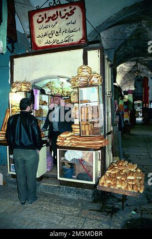 Ein Palästinenser, der Ka'ak-Brot aus seinem kleinen Laden im muslimischen Qt. In der Altstadt von Jerusalem verkauft. Stockfoto