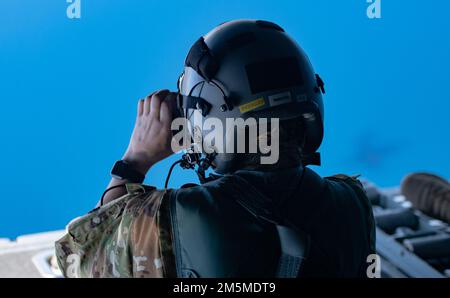 Staff Sgt. Sydney Goddard, ein Lastmeister der Nevada Air National Guard, macht ein Foto, während er auf der Rampe eines C-130 Hercules-Flugzeugs über Lake Tahoe sitzt, am 25. März 2022. Lokale Bürgermeister wurden auf einen Orientierungsflug gebracht, um ihr Bewusstsein für die Nevada Air National Guard zu erhöhen und ihnen zu helfen, die Missionen, die die Airmen täglich ausführen, besser zu verstehen. Stockfoto