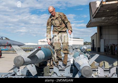 Ein Munitionsspezialist, der dem 4. Munitionsgeschwader zugeteilt ist, bereitet sich vor, inerte Bombeneinheiten aus einem Munitionslager zu entladen, während eines jährlichen Ladungswettbewerbs am Seymour Johnson Air Force Base, North Carolina, am 25. März 2022. Die Richter bewerteten die Besatzungsmitglieder nach ihrer Genauigkeit, Einsatzfähigkeit und Effizienz. Stockfoto