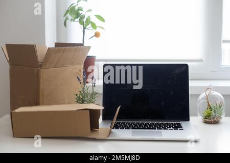 Laptop-Computer am Arbeitsplatz eines Start-up-Unternehmens, Inhaber eines kleinen Unternehmens, internationales Paketlieferkonzept, globales Einkaufsgeschäft Stockfoto