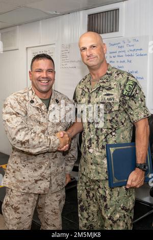 CAMP LEMONNIER, Dschibuti (26. März 2022) USA Marinewaffenmeister Matthew A. Lopez wird von den USA gratuliert Navy Command Master Chief Sean Baney, Camp Lemonnier, Djibouti (CLDJ), während einer Abschlussfeier für das Bestehen des C-NLDF-Kurses (Command-Navy Leader Development Facilitator), um Ausbilder für das flottenweite ELD-Programm (Enlisted Leader Development) zu werden. CLDJ dient als Expeditionsbasis für US-Streitkräfte, die Schiffe, Flugzeuge und Personal unterstützen, die die Sicherheit in ganz Europa, Afrika und Südwestasien gewährleisten. Der Stützpunkt ermöglicht die See- und Kampfeinsätze i Stockfoto