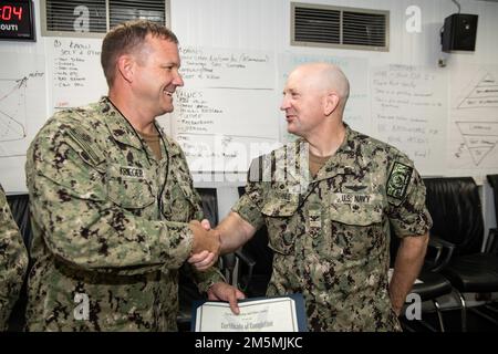 CAMP LEMONNIER, Dschibuti (26. März 2022), Chief Electronics Technician Nathan J. Krieger, wird von den USA beglückwünscht Navy Capt. David Faehnle, kommandierender Offizier im Camp Lemonnier, Dschibuti (CLDJ), während einer Abschlussfeier für das Bestehen des Lehrgangs für Command-Navy Leader Development Facilitator (C-NLDF), um Ausbilder für das flottenweite ELD-Programm (Enlisted Leader Development) zu werden. CLDJ dient als Expeditionsbasis für US-Streitkräfte, die Schiffe, Flugzeuge und Personal unterstützen, die die Sicherheit in ganz Europa, Afrika und Südwestasien gewährleisten. Die Basis ermöglicht Seeschifffahrt und Kämmen Stockfoto