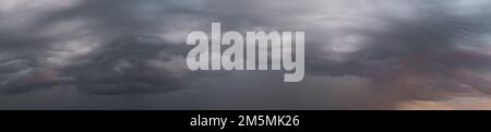 Weite Panoramaaufnahme epischer Sturmwolken bei Sonnenaufgang, Naturhintergrund Stockfoto