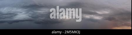 Weite Panoramaaufnahme epischer Sturmwolken bei Sonnenaufgang, Naturhintergrund Stockfoto
