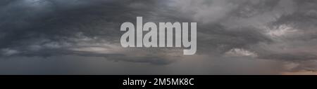 Weite Panoramaaufnahme epischer Sturmwolken bei Sonnenaufgang, Naturhintergrund Stockfoto