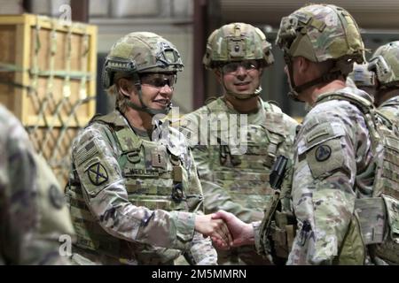 Chief Warrant Officer 4 Amanda J. Weidler, Senior Airdrop Advisor des 3. Expeditionary Sustainment Command, schüttelt Brig die Hand. General Lance G. Curtis, kommandierender General, 3. ESC, während einer Ansage bei einem taktischen Dining-in in Camp Arifjan, Kuwait, 26. März 2022. Curtis war Gastgeber der Veranstaltung, um die Bräuche und Traditionen des US-Militärs zu wahren, Kameradschaft und Esprit de Corps zu fördern und die Leistungen der Einheit während ihres Einsatzes zur Unterstützung des 1. Theater Sustainment Command anzuerkennen. Stockfoto