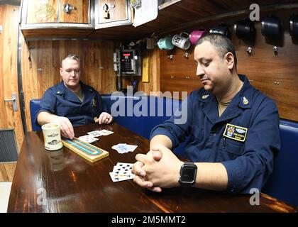 220326-N-GR655-0192 GROTON, Connecticut (26. März 2022) – Senior Chief Petty Officer Travis Grammer, Left, Chef des Bootes des Virginia-Unterseeboots USS Delaware (SSN 791), spielt Cribbage mit Senior Chief Petty Officer Christopher Atiencia, einem unterwiesenen Chef des Bootes, während des 26. März 2022. Die 132-köpfige Besatzung von Delaware reiste nach Wilmington, Delaware, um an einwöchigen Gedenkveranstaltungen zu Ehren der Inbetriebnahmezeremonie des Schiffes teilzunehmen, die aufgrund der damaligen COVID-Beschränkungen im April 2020 administrativ stattfand. Delaware, das siebte Navy-Schiff der USA und Stockfoto