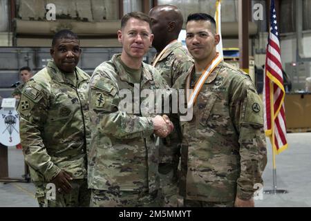 Brigg. General Lance G. Curtis, kommandierender General, 3. Expeditionary Sustainment Command, schüttelt sich die Hand mit Sergeant Major Jeovannie Melendez-Morales während eines taktischen Essens im Camp Arifjan, Kuwait, 26. März 2022. Curtis überreichte Melendez-Morales den Bronze Order of Mercury Award in Anerkennung seiner Beiträge für die USA Das Signal-Korps Der Armee. Stockfoto