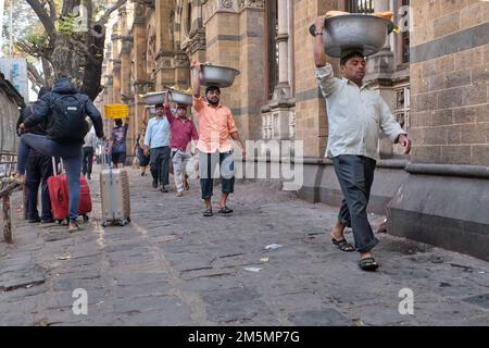 Gepäckträger mit Fischkörben auf dem Kopf, am Chhatrapati Shivaji Maharaj Terminus (CMST) in Mumbai, Indien, um die Körbe mit dem Zug weiterzuleiten Stockfoto