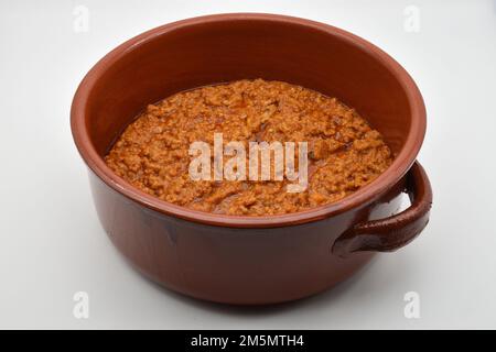 Italienisches Bolognese-Ragu in einem Topf, isoliert auf weißem Hintergrund. Rind und Schweinelende Ragu. Köstlicher Komfort, gesundes Essen. Stockfoto