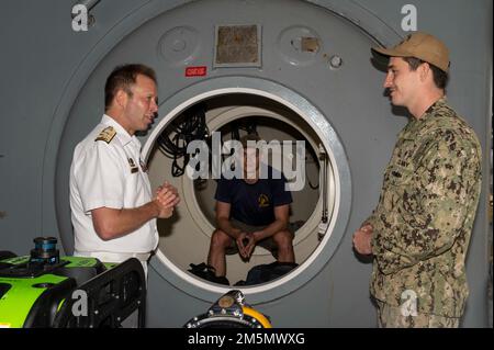 SYDNEY (28. März 2022) – Navy Diver 1. Klasse Chace Benefield, rechts, Und Navy Diver 3. Class Antonio SantiagoFigueroa, Center, beide dem Emory S. Land-Class U-Boot Tender USS Frank Cable (AS 40) zugeteilt, erklären ihre Jobs dem Royal Australian Navy Vice ADM. Michael Noonan, Chief of Navy Australia, während einer Rundfahrt durch das Schiff, März 28. Frank Cable ist derzeit auf Patrouille und führt expeditionäre Wartungs- und Logistikaufgaben zur Unterstützung der nationalen Sicherheit im US-7.-Flottenbereich durch. Stockfoto