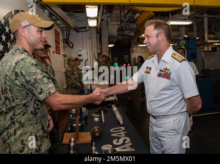 SYDNEY (28. März 2022) – Machinery Repair Repair man 1. Class William Lemaitre, der dem Emory S. Land-Class-U-Boot-Tender USS Frank Cable (AS 40) zugeteilt wurde, erläutert seine Arbeit in der Maschinenwerkstatt dem Royal Australian Navy Vice ADM. Michael Noonan, Chief of Navy Australia, während einer Rundfahrt durch das Schiff, März 28. Frank Cable ist derzeit auf Patrouille und führt expeditionäre Wartungs- und Logistikaufgaben zur Unterstützung der nationalen Sicherheit im US-7.-Flottenbereich durch. Stockfoto