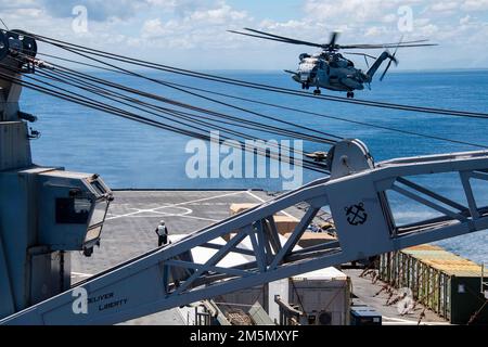 Ein CH-53E Super Stallion Hubschrauber, der dem Marine Heavy Helicopter Squadron 466 (HMH-466) zugewiesen wurde, landet auf dem Flugdeck des nach vorne ausgeregten Amphibiendocks USS Ashland (LSD 48) während des Balikatan 22 vor der Küste der Philippinen, 28. März 2022. Balikatan ist eine jährliche Übung zwischen den Streitkräften der Philippinen und dem US-Militär, die darauf ausgerichtet ist, bilaterale Interoperabilität, Fähigkeiten, Vertrauen und Zusammenarbeit zu stärken, die über Jahrzehnte hinweg gemeinsam genutzt wurde. Balikatan, Tagalog für „Schulter an Schulter“, ist eine langjährige bilaterale Übung zwischen den Philippinen und den Stockfoto