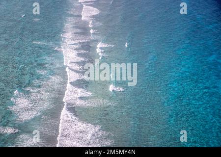 Blick aus der Luft auf das Meer, Blick von oben auf die atemberaubende Natur, den Ozean Hintergrund. Leuchtend blaue Wasserfarben, Lagunenstrand mit Wellen, die an sonnigen Tagen plätschern. Fliegende Drohne Stockfoto