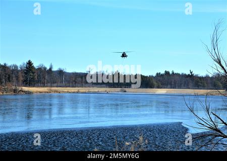 Eine Crew der Nationalgarde der Wisconsin Army UH-60 Black Hawk mit dem 1. Bataillon in Madison, Wisconsin, 147. Aviation Regiment-Zug, der am 28. März 2022 mit Bambi-Eimern in Fort McCoy, Wisconsin, Wasser auf Waldbrände wirft. Mitarbeiter der Feuerwehr von Fort McCoy, der Direktion für öffentliche Arbeiten, natürliche Ressourcen, der Wisconsin Abteilung für natürliche Ressourcen und Flugbesatzung sowie Black Hawk Helikopter des 1. Bataillons, 147. Luftfahrtregiment in Madison, Wisconsin, nahmen an der Feuerschulung während einer vorgeschriebenen Brandverbrennung Teil. Stockfoto