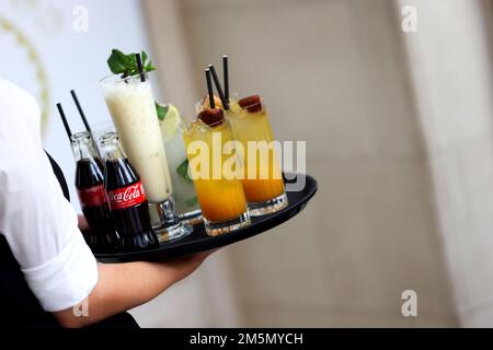 Cocktails und schöne Drinks, die von einer Kellnerin in einem Hotel in London, Großbritannien, serviert werden. Stockfoto