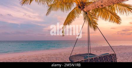 Tropisches Sonnenuntergang-Strandpanorama als Sommerlandschaft mit entspannender Strandschaukel oder Hängematte auf Kokospalmen, weißem Sand und ruhigem Strandbanner Stockfoto