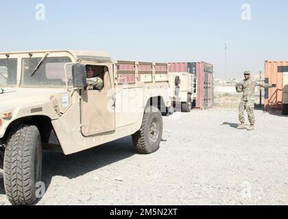 Staff Sgt. Cedric R. Matthews Ground leitet Sgt. Landon M. Schlotfeldt, während er rückwärts in einem Fuhrpark in Camp Arifjan, Kuwait, 28. März 2022 fährt. Die Soldaten, die dem 3. Expeditionary Sustainment Command zugewiesen sind, bereiten ihre Ausrüstung für den Transport zurück zu ihrer Heimatstation in Fort Bragg, N.C., vor Sie sind seit August 2021 im Einsatzkommando des 1. Theater Sustainment Command stationiert. Stockfoto