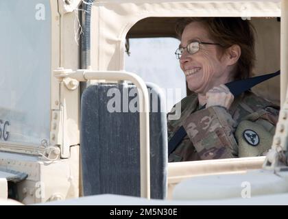 Staff Sgt. Tabatha S. Kearney, eine technische Ingenieurin, die dem 3. Expeditionary Sustainment Command zugewiesen ist, lächelt, während sie ihren Sicherheitsgurt in einem Fuhrpark in Camp Arifjan, Kuwait, anschnallt, 28. März 2022. ‚Spears Ready‘-Soldaten bereiten ihre Ausrüstung für den Transport zurück zu ihrer Heimatstation in Fort Bragg, N.C., vor Sie sind seit August 2021 im Einsatzkommando des 1. Theater Sustainment Command stationiert. Stockfoto