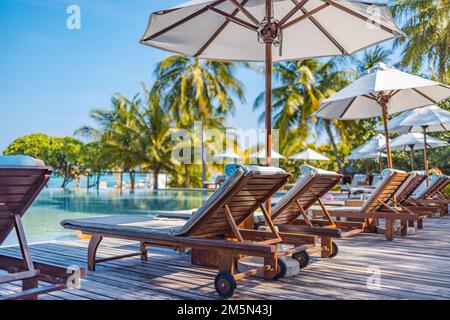 Sonnenschirme und Stühle rund um den Außenpool im Resort-Hotel für Urlaub und Freizeit Lifestyle. Luxuriöses Reiseziel-Konzept, Wellness-Lounge Stockfoto