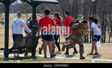 Ein überschwängliches Trio von Teilnehmern der Sheppard NCO Academy 5k Rruck zur Unterstützung des Klassenkameraden Sgt. James Sykes und seiner Familie machen sich auf den Weg durch einen der letzten Kontrollpunkte im Wind Creek Park am Sheppard Air Force Base, Texas, am 28. März 2022. Sykes' Tochter, die 2-jährige Zoey, wurde 2021 mit Leukämie diagnostiziert, und die Unterstützung durch seine Air Force Familie war überwältigend. Stockfoto