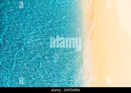 Sommerlandschaft wunderschöne Wellen blaues Meerwasser an sonnigen Tagen. Draufsicht von der Drohne. Meerblick aus der Luft, fantastischer tropischer Natur Hintergrund. Wunderschöne Küste Stockfoto