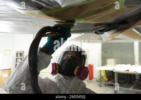 USA Air Force Staff Sergeant. August Hoffman, 325. Wartungs-Geschwader, niedriger, beobachtbarer Handwerker, sandet von der Farbe eines F-22 Raptors auf dem Tyndall Air Force Base, Florida, 28. März 2022. LO Airmen, die dem 325. MXS zugeteilt sind, sind dafür verantwortlich, die Tarnfähigkeiten für die F-22s des 325. Kampfflugflügels zu erhalten. Stockfoto