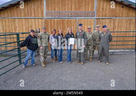 173. Fighter Wing Airmen und lokale Freiwillige machen ein Gruppenfoto nach der Präsentation des Zachary and Elizabeth Fisher Humanitarian Award für Solid Ground Equine Assisted Activities and Therapy in Klamath Falls, Oregon, für ihren Dienst an Militärangehörigen, die sich mit psychischen Gesundheitsproblemen befassen, am 28. März 2022. Der Preis wird aus der gesamten Air National Guard ausgewählt, die aus 50 Staaten, vier Territorien, 90 verschiedenen Flügeln und über 106.000 Mitgliedern besteht. Stockfoto