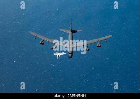 EIN US-AMERIKANISCHER Air Force B-52H Stratofortress fliegt mit einer Qatar Emiri Air Force F-15QA über dem Arabischen Golf, 29. März 2022. Der Flug des Bombers begann in Royal Air Force Fairford, England, und flog über das östliche Mittelmeer, die Arabische Halbinsel und das Rote Meer, bevor er die Region verließ. Stockfoto