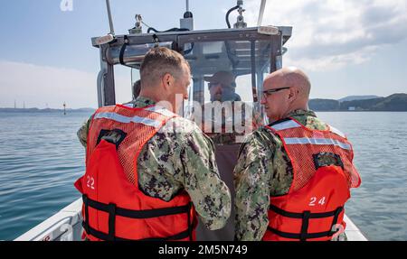 Cmdr. Michael Rigoni, Standortleiter des Naval Supply Systems Command (NAVSUP) Fleet Logistics Center (FLC) Yokosuka Site Sasebo spricht zu Rear ADM Carl Lahti, Commander, Navy Region Japan/Commander, USA Marinestreitkräfte Japan während einer Tour durch die Treibstoffanlagen von Commander, Fleet Activities Sasebo (CFAS) 29. März 2022. Lahti besuchte die NAVSUP FLC Yokosuka Site Sasebo Tankstellen und traf sich im Rahmen eines geplanten Besuchs bei CFAS mit den Führern der Sasebo City, Saikai City und der japanischen Maritime Self-Defense Force, um sich mit der Anlage und der Umgebung vertraut zu machen. Stockfoto