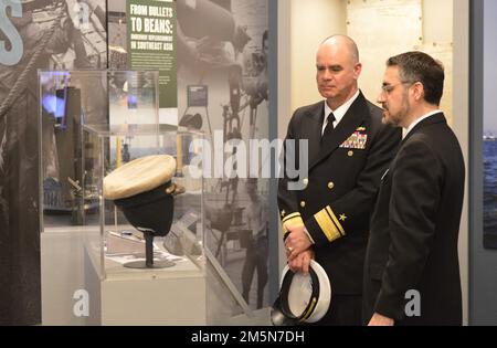 Museumsdirektor John Pentangelo vom Hampton Roads Naval Museum (rechts) und Konteradmiral Brendan McLane, kommandierender Offizier der Naval Surface Force Atlantic Tour die Ausstellung des Museums „der zehntausendtägige Krieg auf See: Die USA Marine in Vietnam, 1950-1975.“ Die Tour fand am Ende einer Zeremonie als Teil des National Vietnam war Veterans Day statt, der vom Museum am 29. März 2022 für Veteranen der Gegend, Militärangehörige und die Öffentlichkeit ausgerichtet wurde. Stockfoto