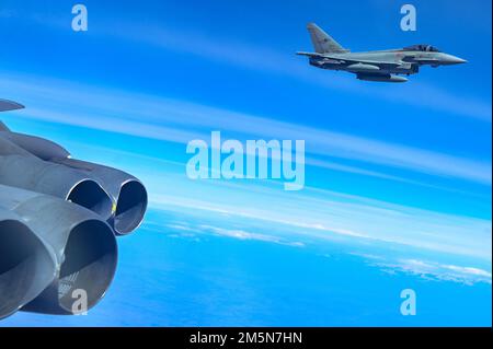 Ein Eurofighter der italienischen Luftwaffe fliegt in Formation mit einer B-52H Stratofestung, die der 69. Expeditionsbombenstaffel in RAF Fairford, England, im Rahmen der geplanten Bomber Task Force Europe-Missionsreihe vom 29. März 2022 zugeteilt wurde. Die Eurofighter begleiteten die EBS 69. auf ihrem Weg nach Osteuropa, um sich in die rumänischen und tschechischen Verbündeten zu integrieren. Stockfoto
