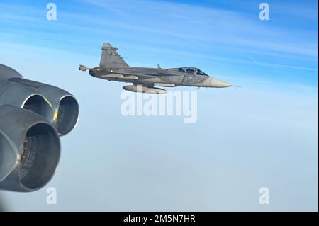Eine tschechische Luftwaffe Saab JAS-39 Gripen begleitet eine B-52H Stratofestung, die der 69. Geschwader der Expeditionsbombe in RAF Fairford, England, im Rahmen der im Voraus geplanten Bomber Task Force Europe-Missionsreihe am 29. März 2022 zugeteilt wurde. Die tschechischen Kämpfer begleiteten den EBS 69. nach ihrer Integration in osteuropäische Verbündete durch Osteuropa. Stockfoto