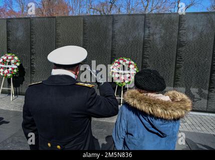 220329-N-BL637-1337 WASHINGTON (29. März 2022) Chef der Marineeinsätze ADM. Mike Gilday, links, grüßt neben Frau Ann Smith während eines Kranzes, der am Vietnam Veterans Memorial am National Vietnam war Veterans Day lag. Anne Smith ist die Witwe von LT. Commander. James A. Smith, der während des Vietnamkriegs an Bord der USS Orisany getötet wurde. Stockfoto