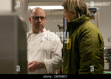 Mitglieder der norwegischen Heimwache Heimevernet, darunter Chefkoch Benn K. Johansen und Andreas Haugan, bereiten am 30. März 2022 im Camp Ripley mehrere Gänge mit Speisen und Desserts für die norwegische Mahlzeit zu. Die Mahlzeit wird aus Norwegen gebracht und als Geschmack Norwegens angeboten. (Minnesota National Guard Photo von Sergeant Mahsima Alkamooneh) Stockfoto