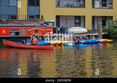 Kinder, die eine paddlesport-Session auf dem Piratenschloss auf dem Kajak genießen. Regents Canal in Camden Town, London. Stockfoto