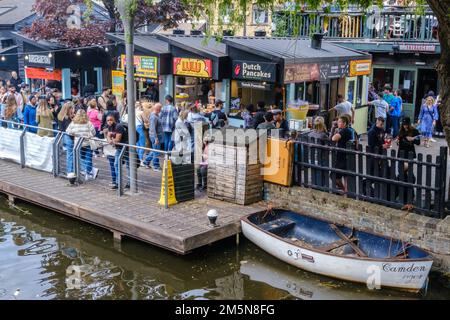 Menschenmassen und verschiedene internationale Fast-Food-Stände am Camden Market, neben dem Regent's Canal, im Zentrum von London, England. Stockfoto