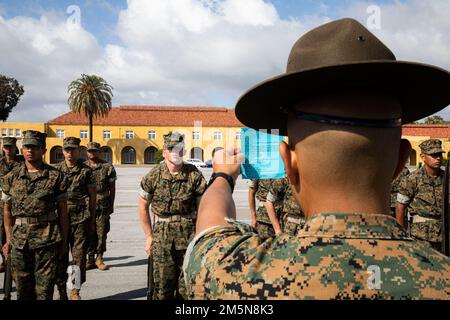 USA Marinekorps Staff Sgt. Rene Torres, leitender Ausbilder bei der Kilo Company, 3. Recruit Training Bataillon, liest eine Trainingskarte vor, bevor er das nächste Kommando während einer Übung zum Marinekorps Recruit Depot San Diego rezitiert, 29. März 2022. Rekrutiert während des Trainings gelernte und ausgeführte Bohrbewegungen als Zug, um Individualismus zu beseitigen und Disziplin zu schaffen. Stockfoto