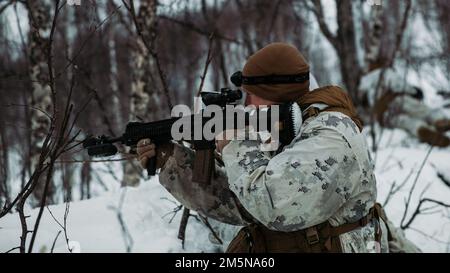 USA Jakob Johnson tritt während der Übung Cold Response 2022, Norwegen, am 29. März 2022 mit einer gegnerischen Truppe in Kontakt. Johnson ist ein Gewehrschütze beim 3. Bataillon, 6. Marineregiment, 2D. Division, II. Marine Expeditionstruppe. Übung Cold Response '22 ist eine alle zwei Jahre stattfindende norwegische nationale Bereitschafts- und Verteidigungsübung, die in ganz Norwegen stattfindet, unter Beteiligung jedes seiner Militärdienste sowie von 26 weiteren alliierten Nationen und regionalen Partnern der Nordatlantikvertrags-Organisation. Stockfoto