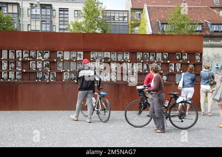 Touristen studieren Fotos von Opfern, die bei der Flucht aus der DDR in der Gedenkstätte Berliner Mauer oder der Gedenkstätte Berliner Mauer in Berlin starben Stockfoto