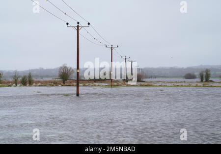 Das Wasser bedeckt Felder in der Nähe des Dorfes Muchelney in Somerset. Der Meteorologe Simon Partridge von Met Office sagte: "Das Wetter in Großbritannien wird wegen des Wetters in den USA durch weitere nasse und windige Wetterperioden aufgrund der Verstärkung des Jetstroms unruhig bleiben." Foto: Freitag, 30. Dezember 2022. Stockfoto