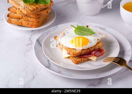 Scheibe getoastetes Brot mit Schinken und Spiegeleiern Stockfoto