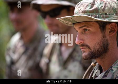 USA Air Force Tech Sgt. Derek Spinale, 38. Rettungsschwadron Blue Team Pararescueman, und seine Teamkollegen lernen von den Lehrern der Tactical Tracking Operations School im Dschungel von Wahiawa, Hawaii, vom 29. März 2022 über das Tracking. Das Team aus Sanitätern und einem Joint Terminal Attack Controller übte die Verfolgung der TTOS-Lehrer und der anderen durch unterschiedliches Gelände mithilfe taktischer Formationen. Die 38. RQS Blue Team Pararescuemen trainierten in der Dschungelkriegsführung, um die Rettungstaktiken, -Techniken und -Verfahren des Personals für die Region Indo-Pazifik anzupassen. Stockfoto