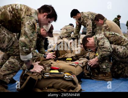 In Vorbereitung auf die Übung Orion, USA 10. Special Forces Group zugeteilte Army Green Berets und beigefügte Navy Sprengstoff Ordnance Disposal-Techniker überprüfen ihre Ausrüstung vor der Flugausbildung in der Abwurfzone nahe Elefsina, Griechenland, 29. März 2022. Übung Orion stärkt Griechenland als Führer der regionalen Spezialeinsatzkräfte, verbessert die Interoperabilität über mehrere Bereiche hinweg und stärkt die Beziehungen zu NATO- und nicht-NATO-Partnern. Im Mittelpunkt der Übung stehen operative Fähigkeiten, internationale Kooperationen und Schulungen für konventionelle und hybride Kriegsführung Stockfoto