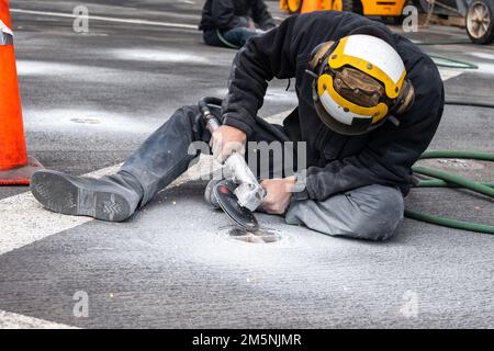 220225-N-VQ947-1029 PAZIFIK (25. Februar 2022) — Aviation Boatswain’s Mate (Handler) Airman Addam Damer führt am 25. Februar 2022 Scheibenschleifen auf einem Gleitösen auf dem Cockpit der Amphibien-Transportanlage der San Antonio-Klasse USS Portland (LPD 27) durch. Matrosen und Marines der Essex Amphibious Ready Group (ARG) und der 11. Marine Expeditionary Unit (MEU) führen derzeit Routineeinsätze in der US-3.-Flotte durch. Stockfoto