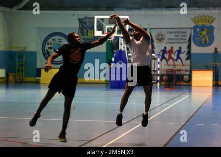 USA Soldaten, die dem 101. Brigaden-Stützbataillon, dem 1. Panzerbrigade-Kampfteam, der 1. Infanteriedivision zugeteilt sind, spielen am 25. Februar 2022 in Skwierzyna ein Basketballspiel. Soldaten der 101. BSB nahmen an verschiedenen Sportveranstaltungen Teil, die organisiert wurden, um den Zusammenhalt der Einheit zu verbessern und gesunde Wettkämpfe zwischen den Soldaten zu haben. Stockfoto