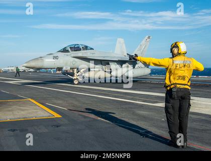 220225-N-MW880-1195 ATLANTISCHER OZEAN (FEB 25, 2022) Aviation Boatswain’s Mate (Handling) 1. Class Basir Riddick, zugewiesen an den Flugzeugträger USS George H.W. Bush (CVN 77) leitet während des Tailored Ship’s Training Availability/Final Evaluation Problem (TSTA/FEP), Februar 25, ein F/A-18F Super Hornet Flugzeug, das an das Strike Fighter Squadron (VFA) 103 angeschlossen ist. TSTA/FEP ist eine mehrphasige Trainingsentwicklung, die der Crew eine solide Grundlage für die Betriebskompetenz auf Einheitenebene bietet und die Fähigkeit des Schiffes, sich selbst zu trainieren, verbessert. George H.W. Bush bietet der nationalen Kommandobehörde flexible, t Stockfoto