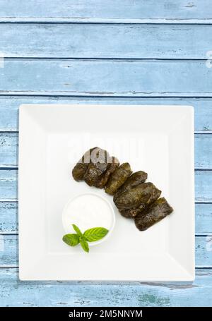 Libanesische türkische griechische Küche, mediterrane Region. Mit Yoghurt Sauce Top View lokaler Name; Yaprak Sarma oder Dolmadika, Dolma, Dolmades Stockfoto