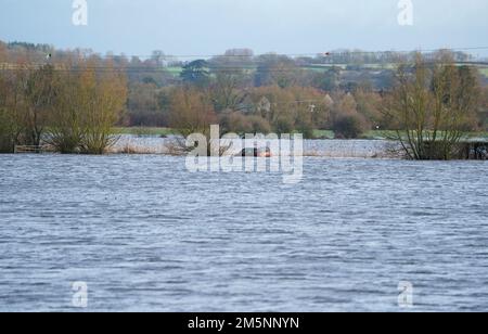 Ein verlassenes Auto im Hochwasser in der Nähe des Dorfes Muchelney in Somerset. Der Meteorologe Simon Partridge von Met Office sagte: "Das Wetter in Großbritannien wird wegen des Wetters in den USA durch weitere nasse und windige Wetterperioden aufgrund der Verstärkung des Jetstroms unruhig bleiben." Foto: Freitag, 30. Dezember 2022. Stockfoto